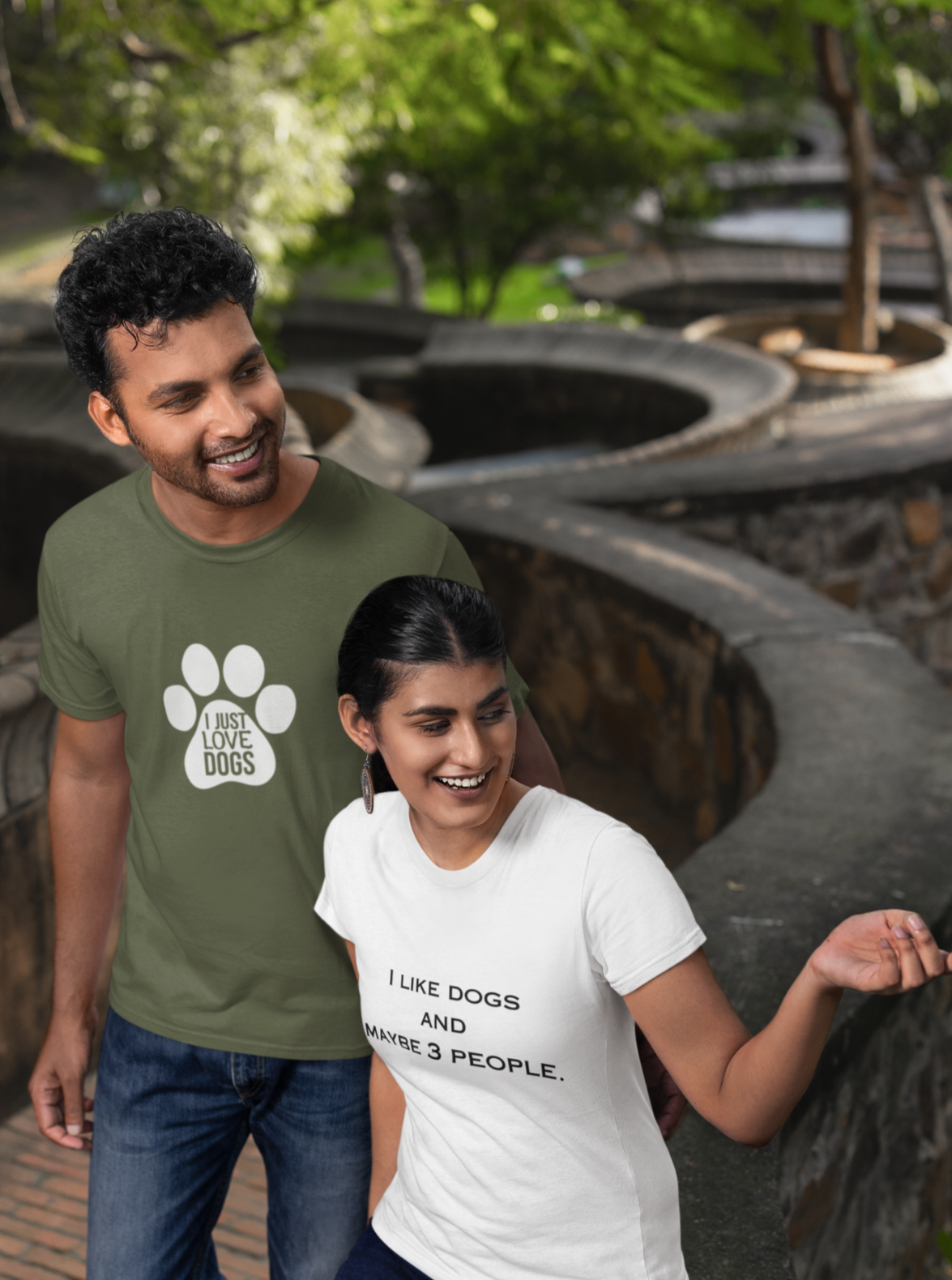 Two people wearing t-shirts with text and a paw print design, standing outdoors.